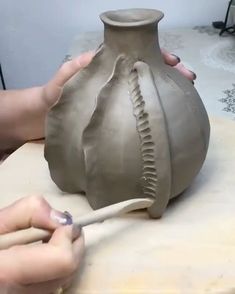 a person is making a vase out of clay