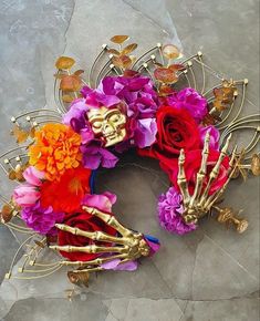 a skeleton wreath with flowers in it on the ground next to a wall or floor