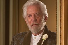 an older man with a white rose in his lapel