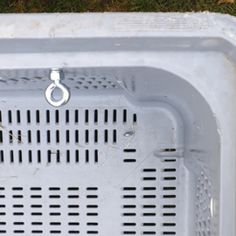 an old white washing machine sitting in the grass with no one on it's side