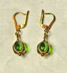 Excellent condition. Stamped 14K.  Pair weighs 5.7 grams. Total length of earrings is 1 1/2 inch, drop measures approx. 3/4 inch.  Three oval peridot cabochons on each earring that measure approx. 8 x 6.5mm. Classic Green Clip-on Earrings, Formal Drop Cabochon Earrings, Green Pierced Earrings For Formal Occasions, Formal Green Pierced Earrings, Classic Green Peridot Earrings, Formal Dangle Earrings With Cabochon, Green Teardrop Clip-on Earrings For Formal Occasions, Oval Green Clip-on Earrings, Elegant Green Cabochon Earrings