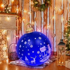 a large blue christmas ornament sitting on top of a wooden floor next to a fireplace