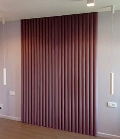 an empty room with wooden flooring and vertical blinds on the wall behind it is a radiator