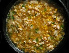 a pot filled with chicken and corn soup