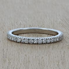 a white gold wedding band with round diamonds on the inside and outside, sitting on a furnishing