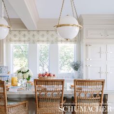 the dining room table is set for four with wicker chairs and place settings on it