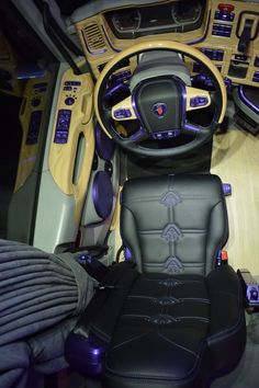 the interior of a car with black leather seats and purple trim on the steering wheel