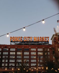 a large sign that reads pong city market on top of a brick building at dusk