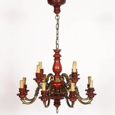 a red chandelier with many candles hanging from it's sides and two lights on each side