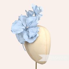 This gorgeous 'Katie May' millinery flower mount is stunning! It's made from shaped and wired light blue silk petals that make up one large flower at it's base followed by 2 smaller flowers and wired leaves at the tip. Each flower has a cluster of stamens at the centre and is attached to a short wired stem that is finished in rolled silk. It's large size makes it ideal for trimming hats and for making an instant fascinator!  Flower measures approximately 13cm (5.1 inches) wide and 20cm (7.8 inch Elegant Blue Fascinator With Handmade Flowers, Spring Wedding Flower-shaped Fascinator, Luxury Flower-shaped Wedding Fascinator, Elegant Flower-shaped Adjustable Fascinator, Luxury Flower-shaped Women's Fascinator, Katie May, Millinery Supplies, Bridal Fascinator, Flower Fascinator