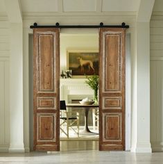 an open door leading to a dining room with white walls and wood trimmings