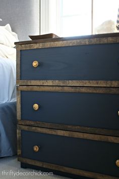 a blue dresser with gold handles in a bedroom