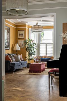 a living room filled with lots of furniture and a chandelier hanging from the ceiling