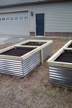 three metal planters in front of a house