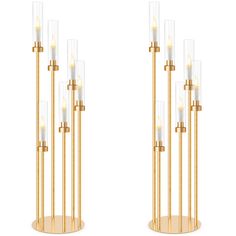 a pair of tall gold and clear glass candlesticks with lights on each end