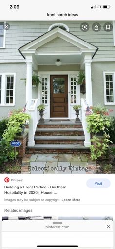 the front door of a house with steps leading up to it and plants on either side