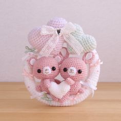 two crocheted teddy bears sitting on top of a wooden table