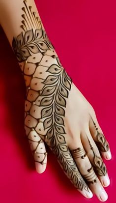 a woman's hand with henna tattoos on it