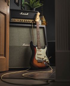 an electric guitar sitting on top of a table next to a speaker and amps