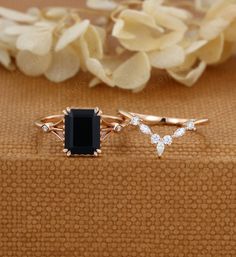 two different types of rings sitting on top of a table next to some white flowers