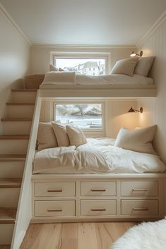 two bunk beds with white linens and pillows in a small room next to stairs