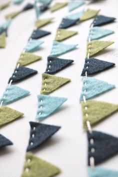 a close up of a number of small triangles on a white table with beading