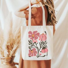 Carry your essentials in style with our 'Boho Floral' tote bag. Adorned with an enchanting array of bohemian-inspired flowers, this bag combines functionality with free-spirited beauty. Crafted from durable materials, it's perfect for day trips, market visits, or everyday use.  This 100% cotton bag comes in one size - 15" x 16"- perfect for everyday wear.  The bag features 20" handles (made from the same canvas), making it easy to carry even with a week's worth of shopping. .: 100% cotton canvas .: Available in natural and black colors .: Heavy fabric (12 oz/yd² (406.9 g/m .: Sewn-in label Flowers Tote, Floral Tote Bag, Canvas Making, Free Spirited, Boho Floral, Abstract Flowers, Cotton Bag, Sew-in Labels, Canvas Bag