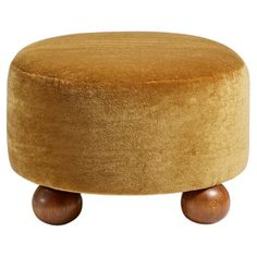 a round foot stool with wooden legs