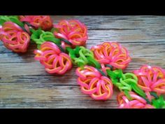 four small plastic flowers on a wooden surface with green stems and pink petals in the center