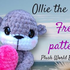 a stuffed animal holding a pink heart next to the ocean with text overlay that reads ollie the free crochet pattern