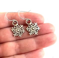 Love these small silver snowflake earrings! Perfect for your favorite winter adventurer! The circle snowflake charms are 15 mm by 21mm and are silver toned. They are silver plated brass, and nickel free and lead free. Please choose either silver plated hooks (as seen in the photos) or solid sterling hooks. A great gift for that special someone who has everything and loves snow! Winter Gift Drop Earrings, Snowflake Earrings For Winter Gift, Winter Snowflake Earrings For Gifts, Silver Snowflake Earrings For Gift, Nickel-free Snowflake Jewelry For Gift, Sterling Silver Snowflake Earrings, Silver Snowflake Earrings, Black Cat Superstition, Snow Adventure