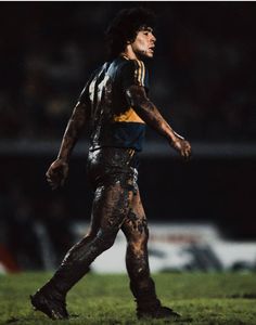 a soccer player covered in mud walking on the field