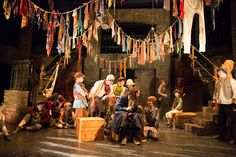 children are sitting on the floor in an old fashioned stage setting