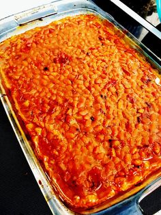 a large casserole dish sitting on top of a stove in a pan with sauce