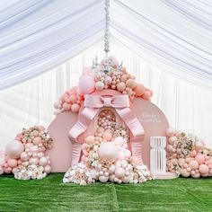 a pink and white wedding arch with balloons