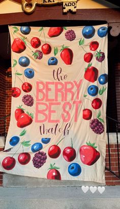 a large banner hanging from the side of a building with cherries and berries on it