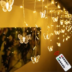 the butterfly string lights are hanging from the ceiling and have remote controls attached to them