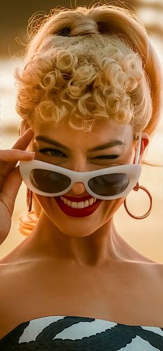 a woman wearing sunglasses with her hair in a bun