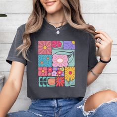 Add a touch of boho to your wardrobe with our Boho Flower T-Shirt. Featuring a beautiful floral design, this shirt will add a unique and playful touch to your style. Embrace your inner flower child and stand out from the crowd with this abstract yet stylish t-shirt. Hippie Multicolor T-shirt For Spring, Casual Retro Print Top For Spring, Bohemian Spring T-shirt With Graphic Print, Multicolor Bohemian T-shirt For Spring, Trendy Multicolor Floral Print T-shirt, Hippie Multicolor Floral Print Tops, Casual Multicolor Tops With Floral Patchwork, Casual Multicolor Floral Patchwork Tops, Spring Hippie T-shirt With Screen Print