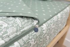 a close up view of a green and white bed cover with an animal pattern on it