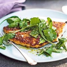 a white plate topped with fish covered in greens