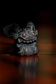 a small statue sitting on top of a wooden table