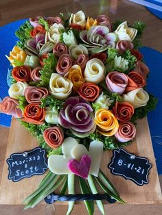 a bouquet of colorful flowers sitting on top of a wooden table next to a chalkboard