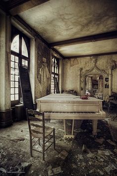 an abandoned room with a piano and chair