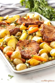 a pan filled with meat, potatoes and carrots