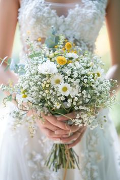 a woman holding a bouquet of flowers in her hands