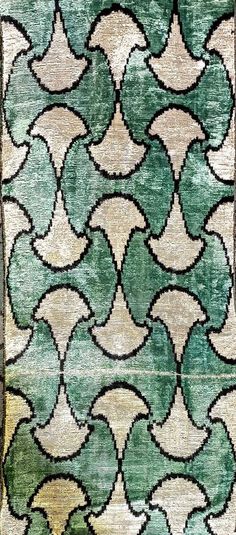 an old rug with green and beige designs