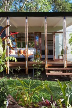 a house that has some plants in the front yard and on the back side of it