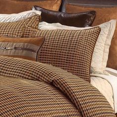 a bed covered in brown and white plaid pillows