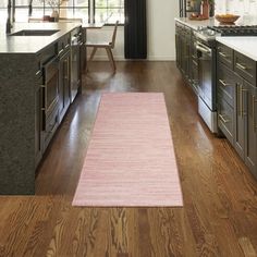 a pink rug in the middle of a kitchen